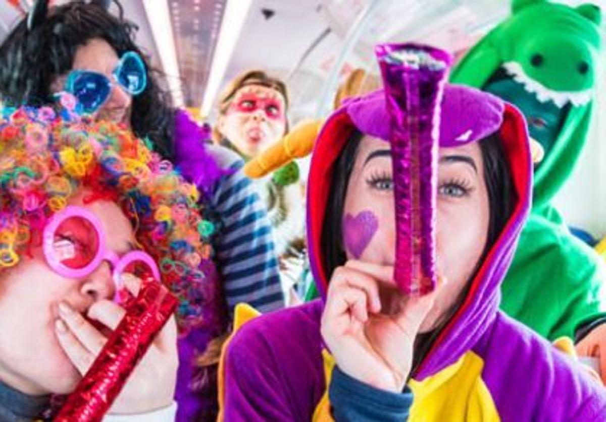 A group of young people in costumes on a Cercanías train.