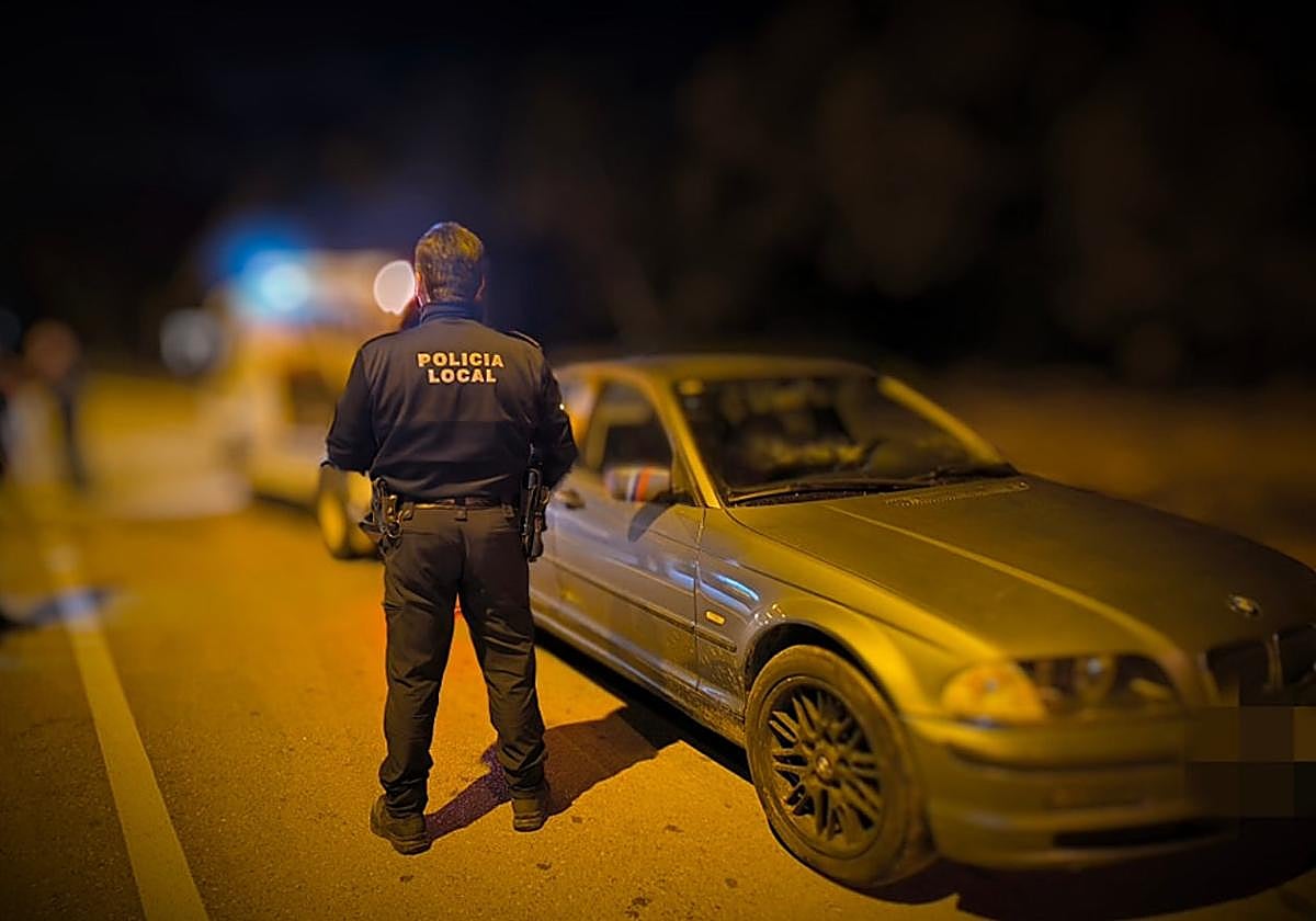 Un agente de la Policía Local junto al vehículo interceptado.