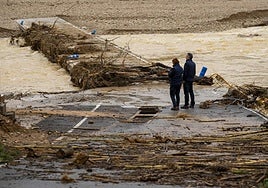 Una pareja observa la crecida del río en Castellón.