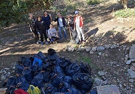 Los voluntarios, con la basura recogida en la ladera del Castillo de Santa Bárbara.