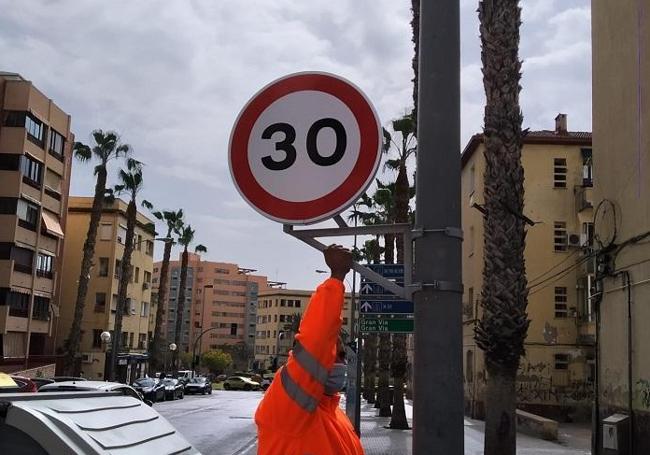 Un operario municipal instala la señal de 30 km/h.