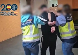 Dos agentes trasladan al detenido en dependencias policiales.