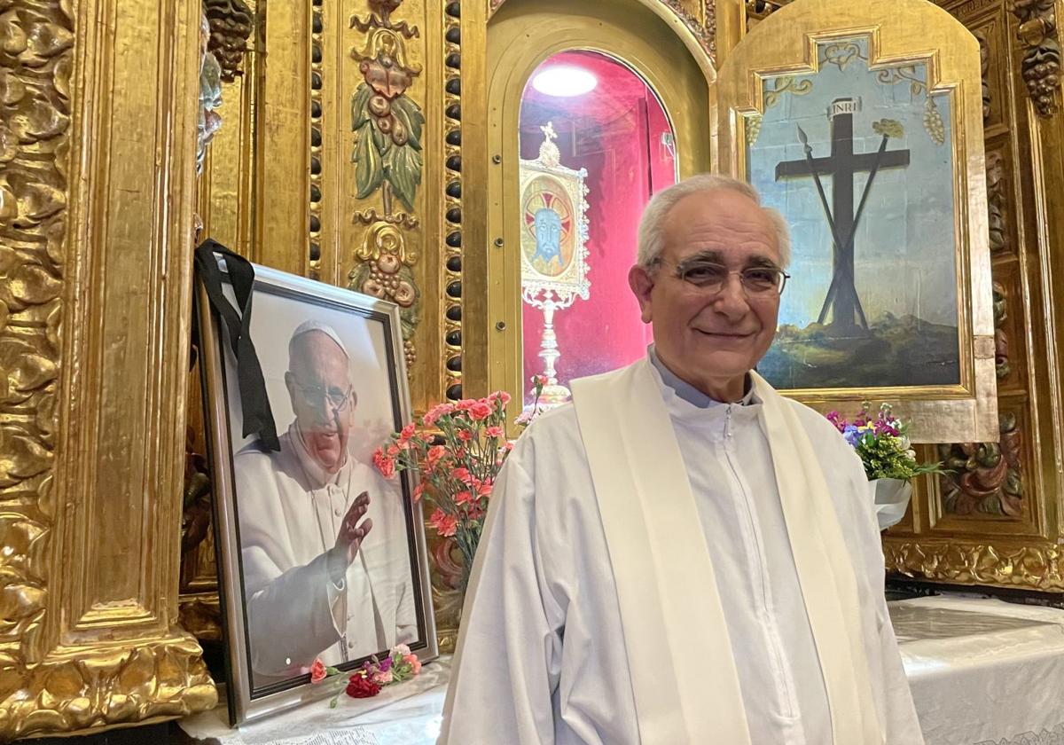 Chaplain Miguel Ángel Cremades in the shrine, next to a photograph of Pope Francis.