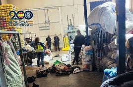Los agentes, en el almacén de ropa usada.