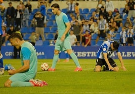 Roger Colomina, abatido sobre el césped, mientras los jugadores del Algeciras celebran la victoria y la permanencia.