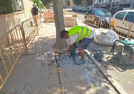 Un operario repara una acera de Alicante, en imagen de archivo.
