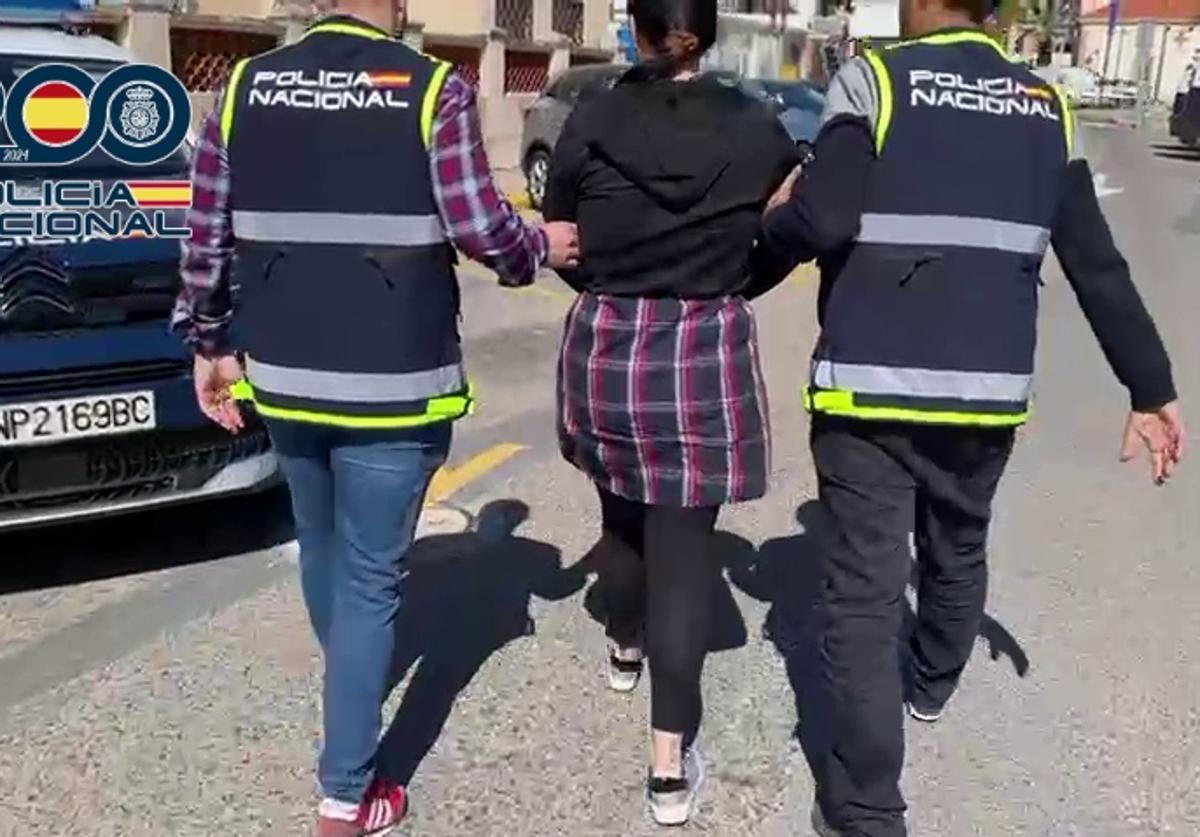 National Police officers escort the detained woman.