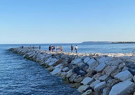 Una decena de personas pasean por el nuevo espigón.