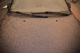Coche cubierto de barro tras lluvia con calima.