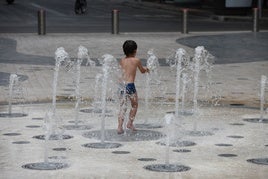 Un niño se refresca en la fuente de la Explanada.