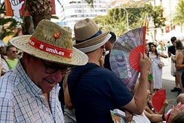 Una persona se abanica durante una mascletà de las Hogueras 2025.