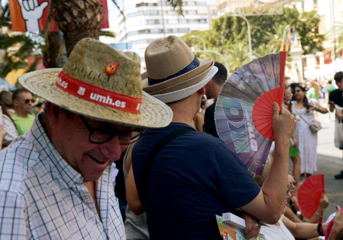 Una persona se abanica durante una mascletà de las Hogueras 2025.