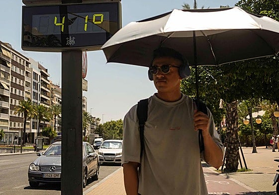 Un hombre camina, junto a un termómetro.