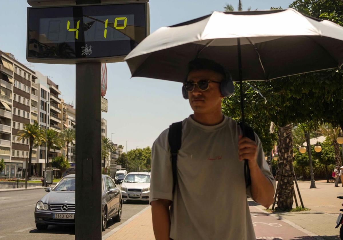 Un hombre camina, junto a un termómetro.