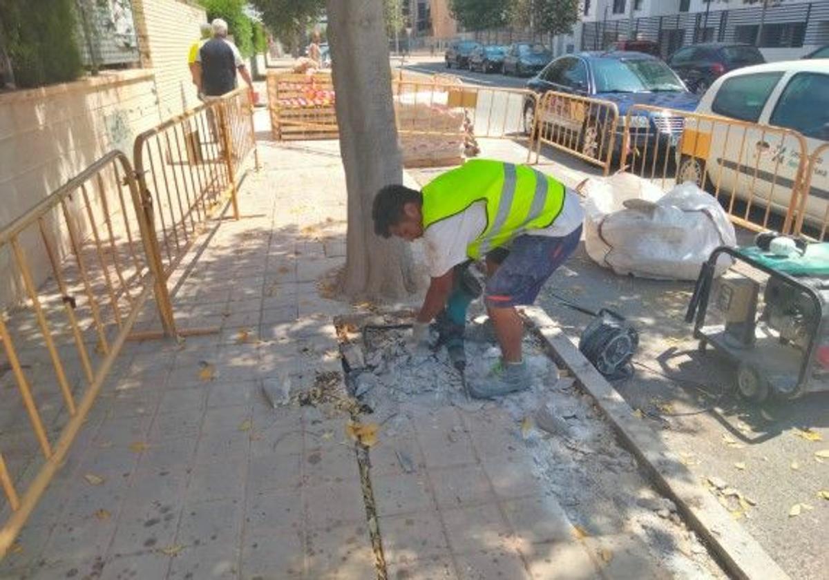 Un operario reparando una acera.