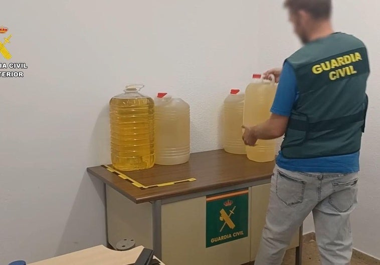 Un guardia civil con algunas de las garrafas decomisadas.