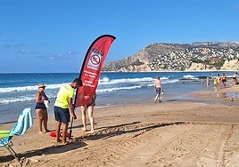 Un socorrista planta la bandera roja que prohíbe el baño.