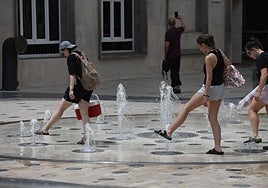 Varias personas se refrescan en Alicante.
