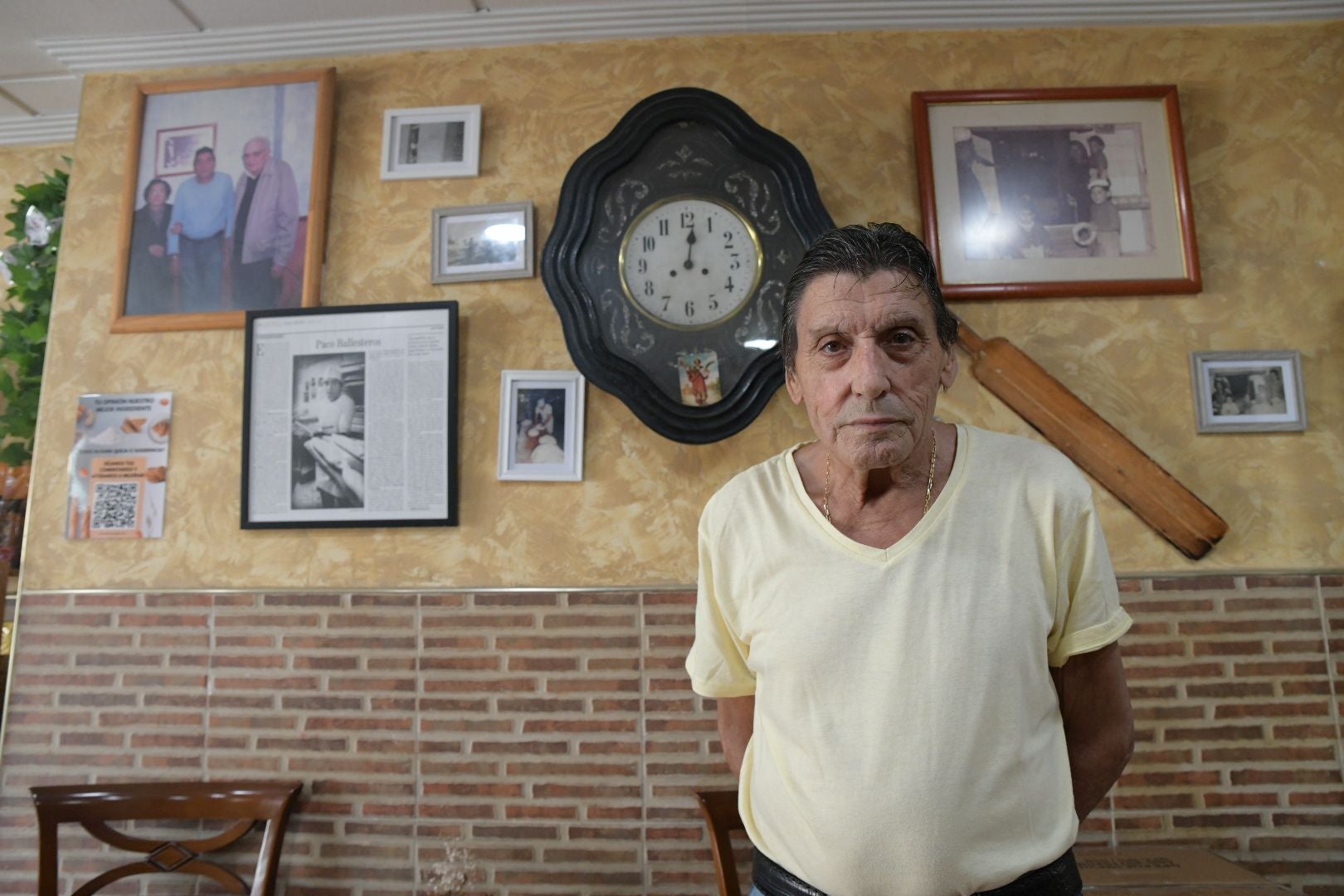 Ballesteros posa junto a los marcos con fotos y recortes de periódico.