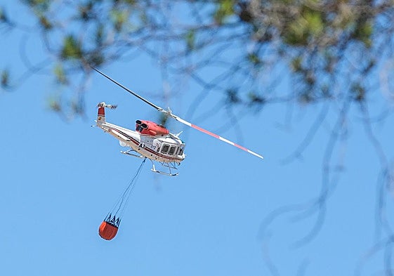 Imagen de archivo de un helicóptero realizando labores de extinción en un incendio forestal.