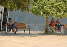 Transeúntes buscan la sombra en Alicante para refugiarse del calor extremo.