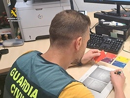 Investigador de la Guardia Civil con las tarjetas robadas.