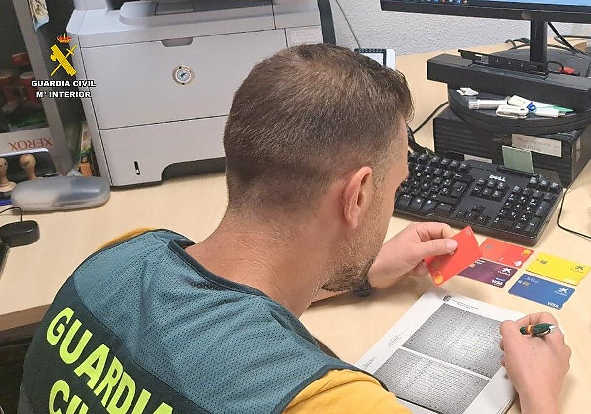 Investigador de la Guardia Civil con las tarjetas robadas.