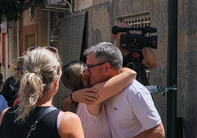 El alcalde de Agost, Juan José Castelló (d), abraza a una vecina cerca de la vivienda.