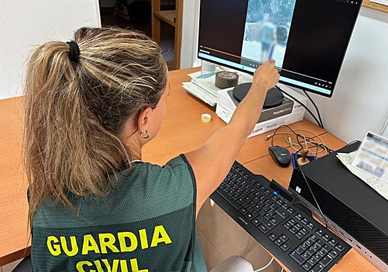 Una investigadora visualiza el vídeo del presunto ladrón aportado por un testigo.