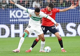Álvaro Rodríguez pelea un balón dividido con Catena en la primera mitad en El Sadar.