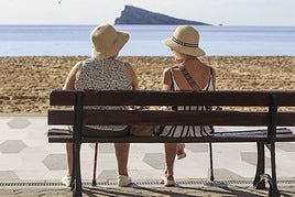 Dos turistas sentadas en el paseo de Benidorm.