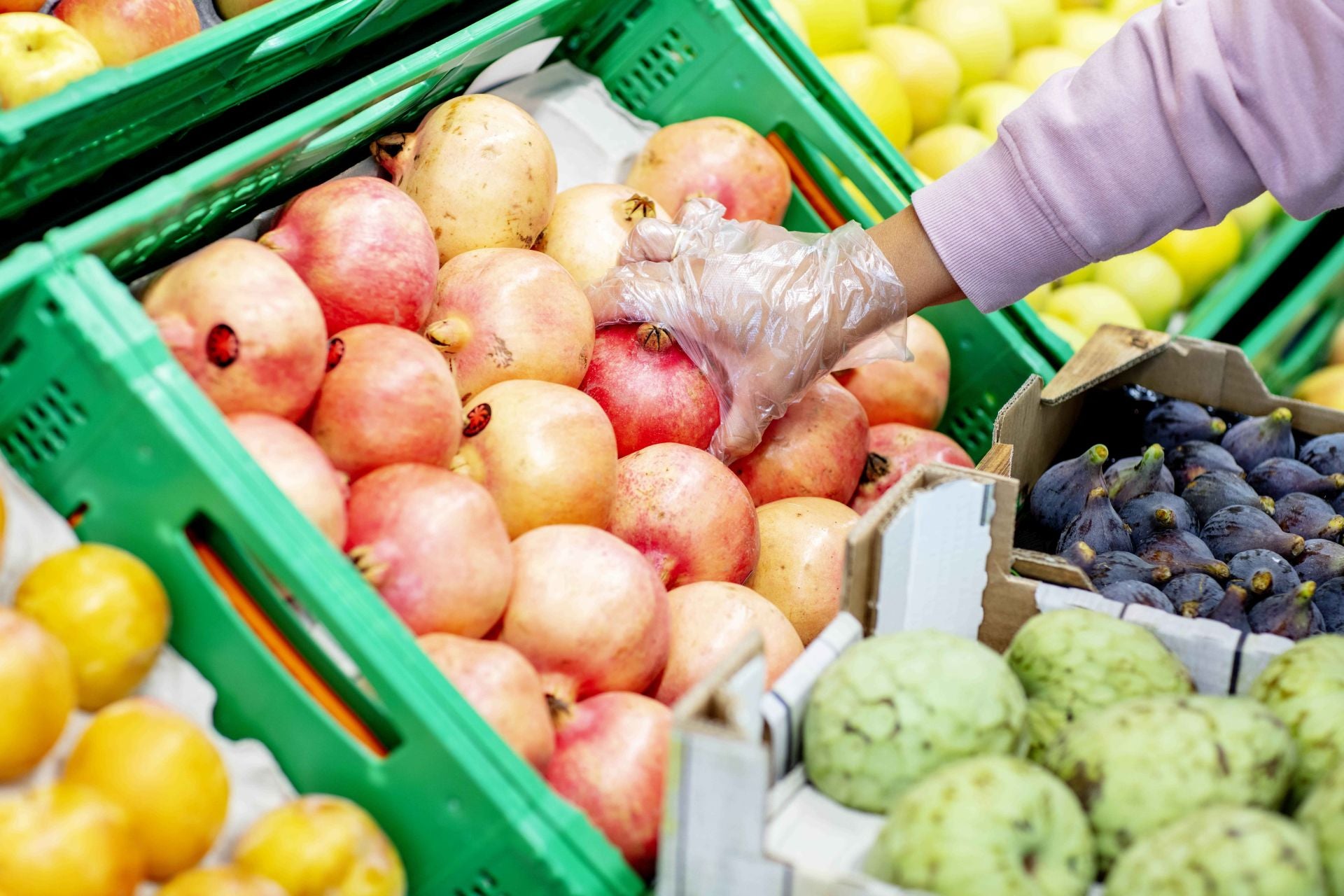 Cliente comprando granada en una tienda Mercadona.