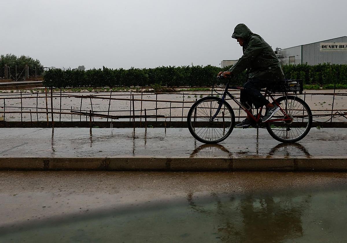 Un hombre en bicicleta, durante los días de lluvia provocaos por la dana 'Alice'.
