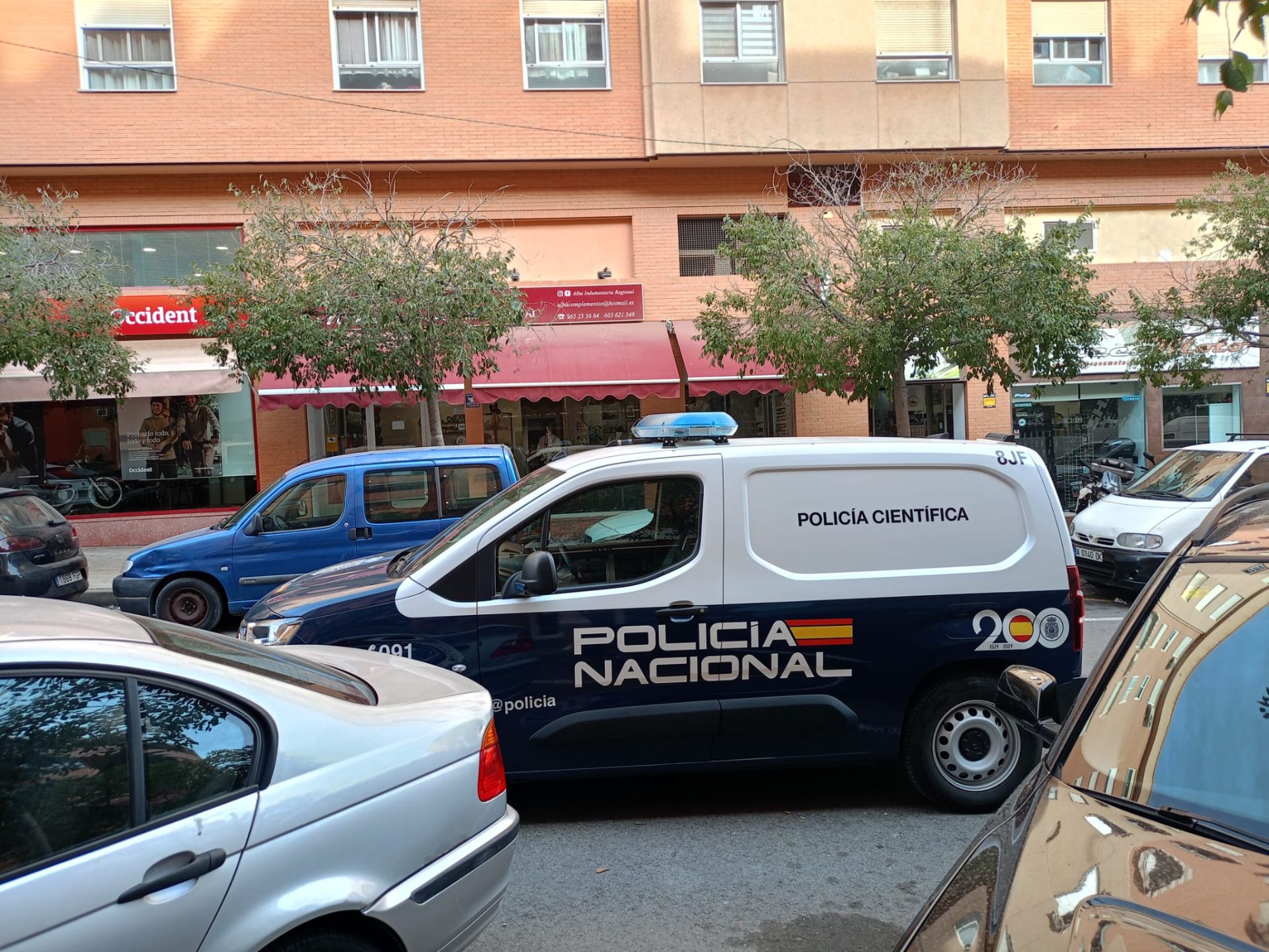 Vehículo de la Policía Nacional Científica en la calle de la lavandería.