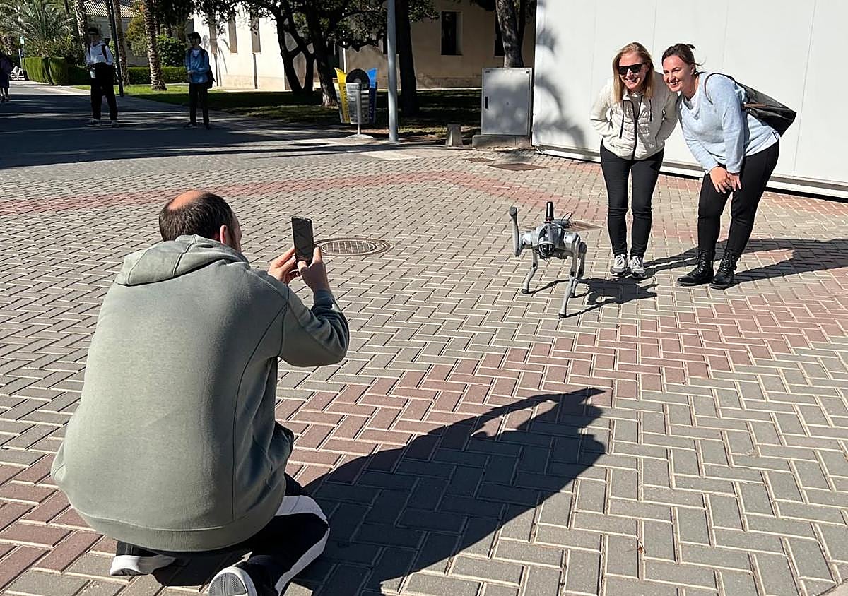 Imagen secundaria 1 - 1. Carmen maneja el robot en el campus de la UA. 2. Francisco Gómez fotografía a varios curiosos con Paws. 3. Paws sobre dos patas. 