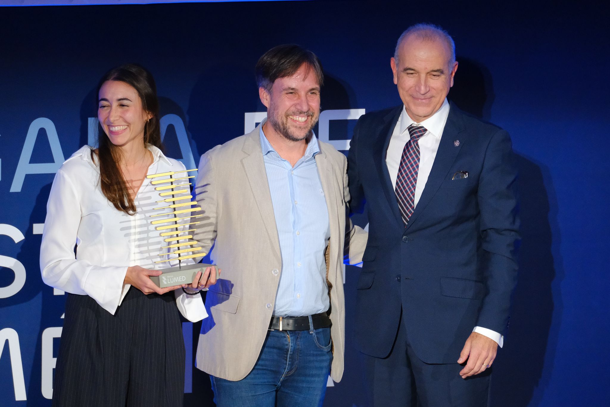 Lorena María Bernal y Enrique de Madaria, galardonados con la ayuda extraordinaria, junto al presidentre del COMA.