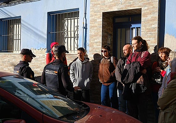 Activistas y policías dialogan de manera previa a que se ejecute el desahucio.